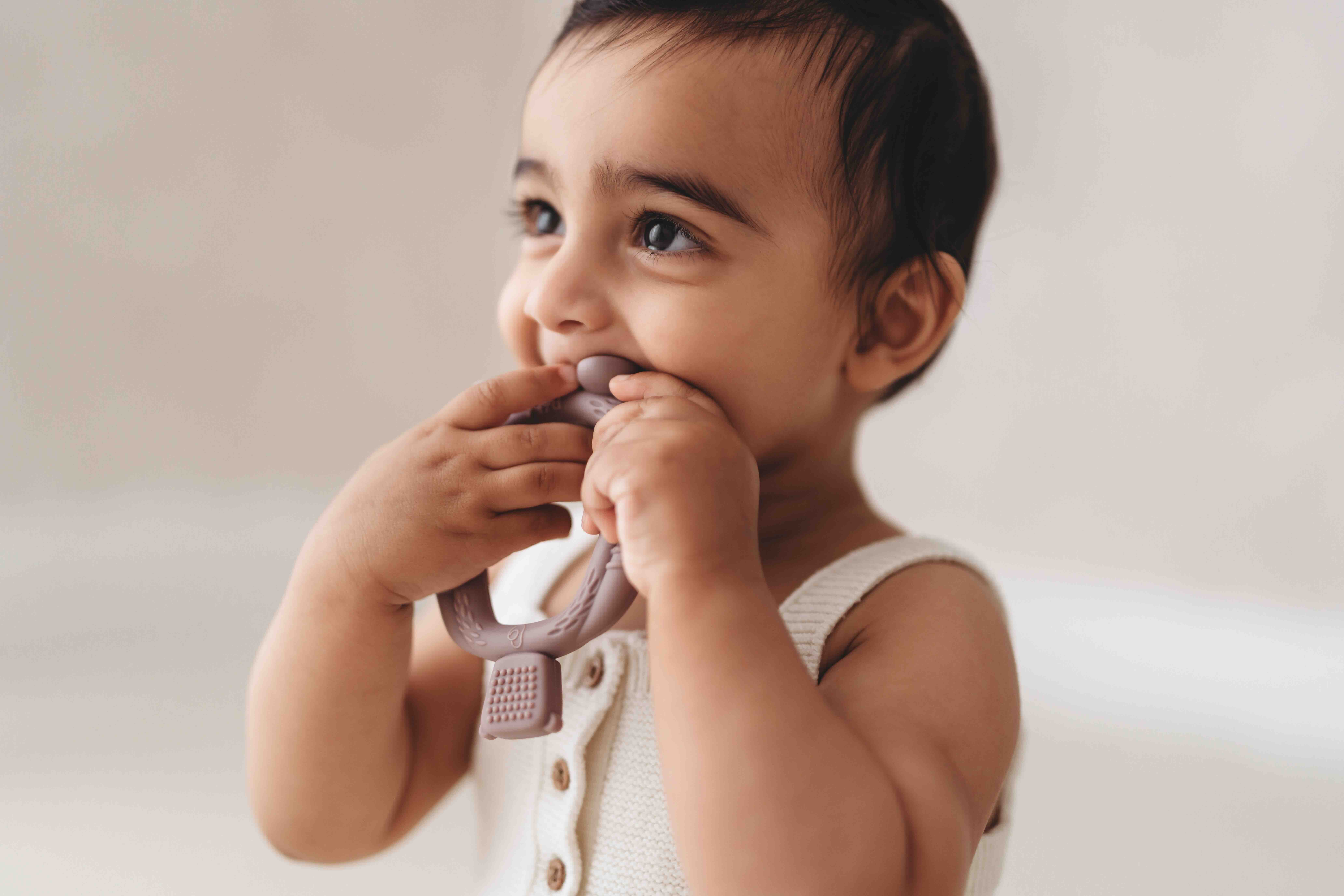 Baby holding and mouthing the Bear Buddy teether
